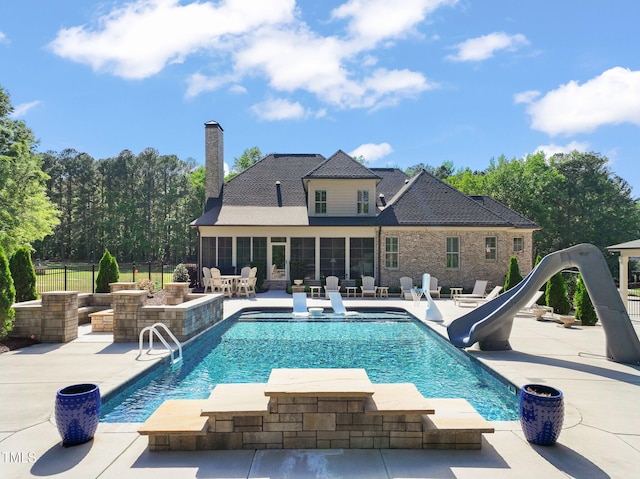 view of pool featuring a water slide, a patio, fence, and a sunroom