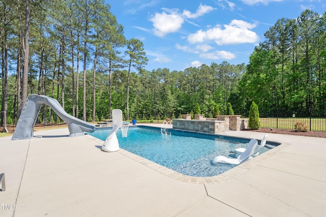 view of swimming pool featuring a water slide, a patio, and fence