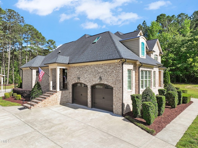 view of side of home featuring concrete driveway, brick siding, a shingled roof, and a garage