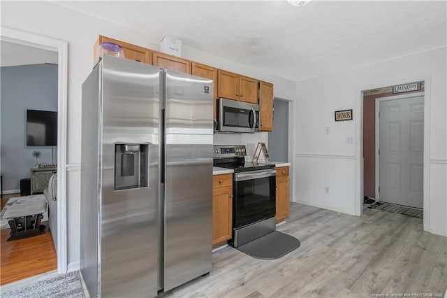 4829 Miranda Dr, Hope Mills, NC 28348 - kitchen with appliances with stainless steel finishes, light wood finished floors, light countertops, and brown cabinets