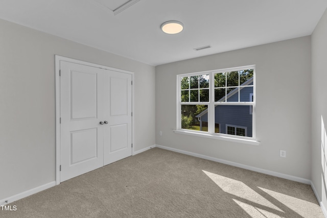 unfurnished bedroom with carpet, baseboards, and a closet