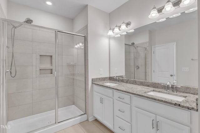full bathroom featuring a shower stall, double vanity, and tile patterned flooring