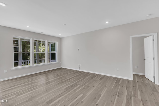 spare room featuring light wood finished floors, baseboards, recessed lighting, and a smoke detector