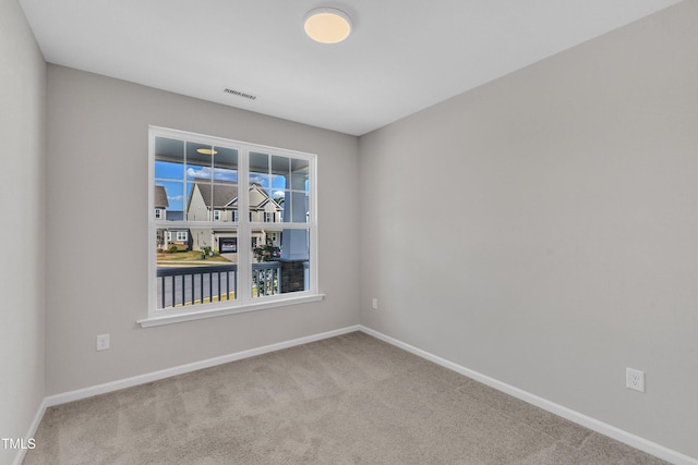 carpeted empty room with baseboards