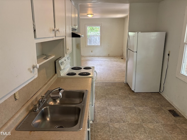 kitchen featuring white appliances, range hood, a sink, and light countertops