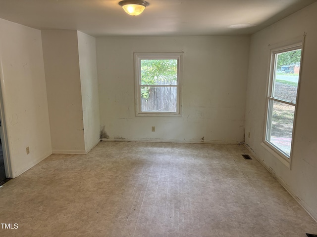 empty room with healthy amount of natural light and tile patterned floors