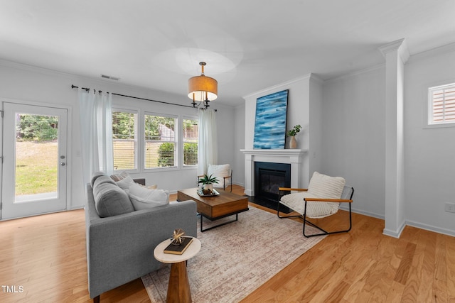 2057 Tanners Mill Dr, Durham, NC 27703 - living area featuring crown molding, light wood finished floors, a fireplace with flush hearth, and plenty of natural light