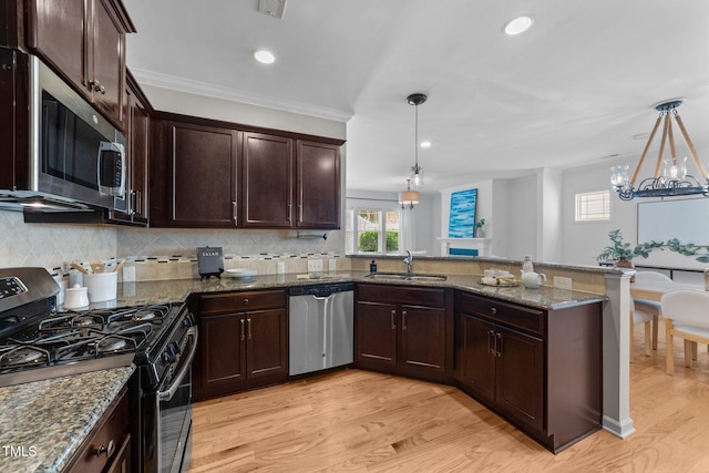 2057 Tanners Mill Dr, Durham, NC 27703 - kitchen with appliances with stainless steel finishes, a sink, light wood-type flooring, a peninsula, and healthy amount of natural light