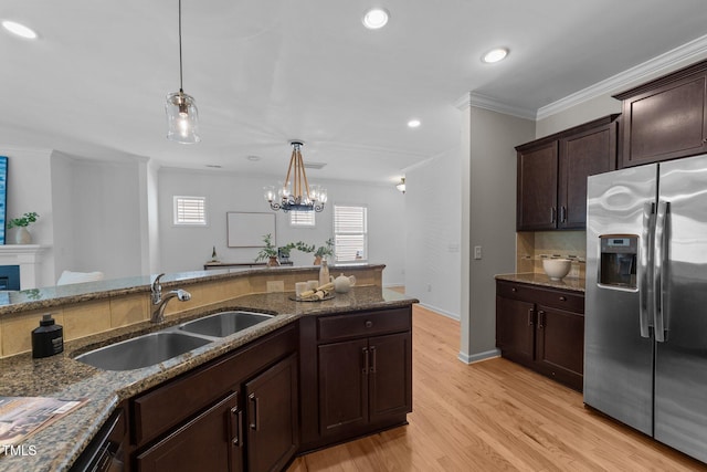 2057 Tanners Mill Dr, Durham, NC 27703 - kitchen with stainless steel fridge, a sink, stone counters, light wood-style floors, and hanging light fixtures