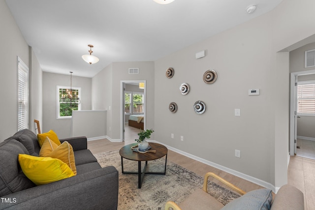 2057 Tanners Mill Dr, Durham, NC 27703 - living area with light wood-style flooring, baseboards, and a chandelier