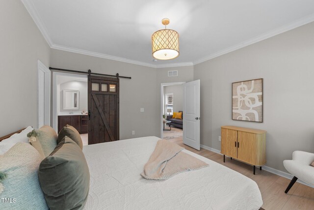 2057 Tanners Mill Dr, Durham, NC 27703 - bedroom featuring ornamental molding, a barn door, light wood-style flooring, baseboards, and ensuite bath