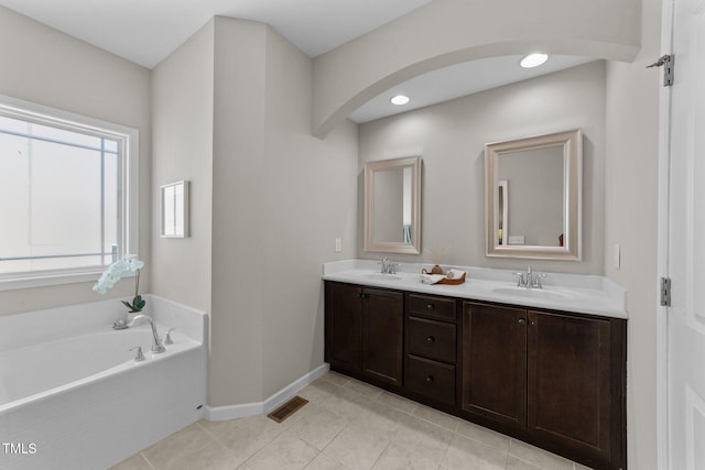 2057 Tanners Mill Dr, Durham, NC 27703 - full bath featuring double vanity, a bath, baseboards, and tile patterned flooring