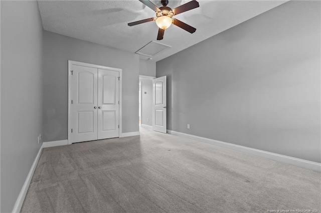 unfurnished bedroom with carpet floors, baseboards, a closet, a ceiling fan, and a textured ceiling