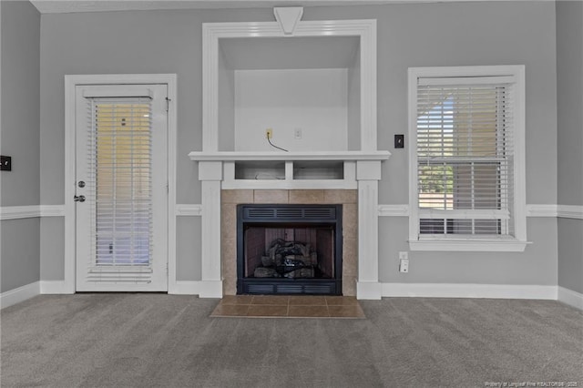 unfurnished living room featuring a fireplace, carpet flooring, and baseboards