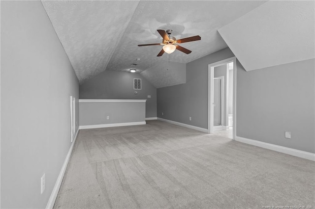 additional living space with a ceiling fan, lofted ceiling, a textured ceiling, carpet, and baseboards