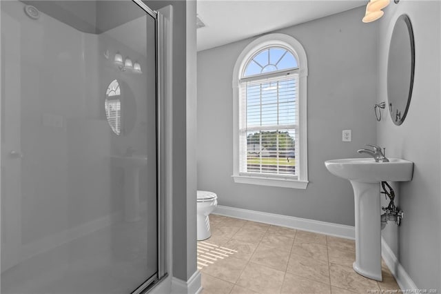 full bathroom with a shower stall, toilet, baseboards, and a sink