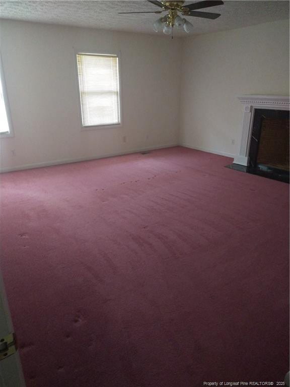 1829 Martindale Dr, Fayetteville, NC 28304 - unfurnished living room featuring carpet flooring, healthy amount of natural light, ceiling fan, baseboards, and a textured ceiling