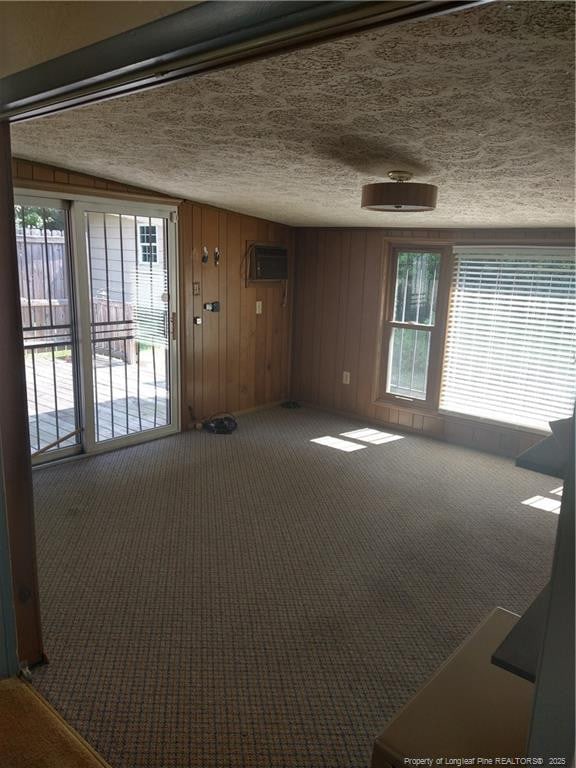 1829 Martindale Dr, Fayetteville, NC 28304 - carpeted empty room with healthy amount of natural light, a textured ceiling, and a wall mounted air conditioner