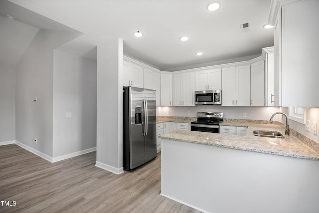 208 W Holt St, Burlington, NC 27217 - kitchen featuring appliances with stainless steel finishes, a sink, a peninsula, light wood-type flooring, and recessed lighting