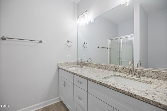 208 W Holt St, Burlington, NC 27217 - full bath featuring a stall shower, wood finished floors, double vanity, and baseboards