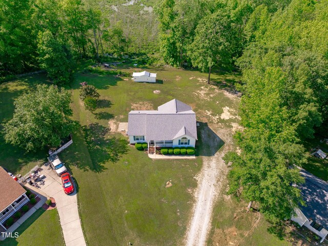 aerial view of property and surrounding area featuring a heavily wooded area