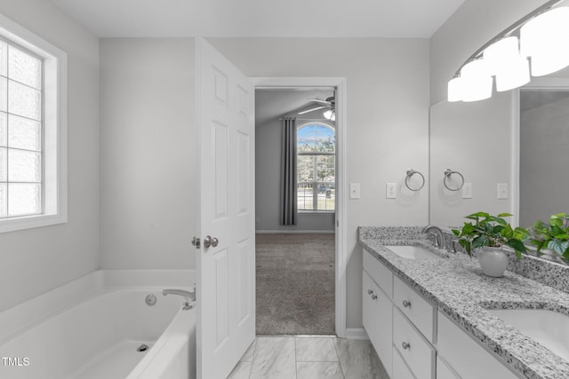 bathroom featuring a bath, marble look tile flooring, double vanity, baseboards, and ceiling fan
