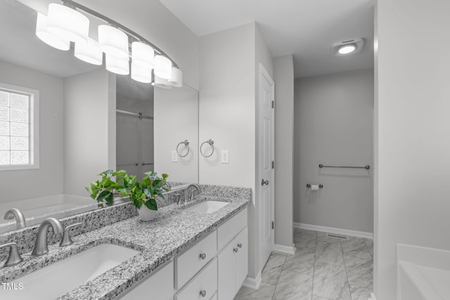 full bath featuring marble look tile flooring, baseboards, a bath, and double vanity