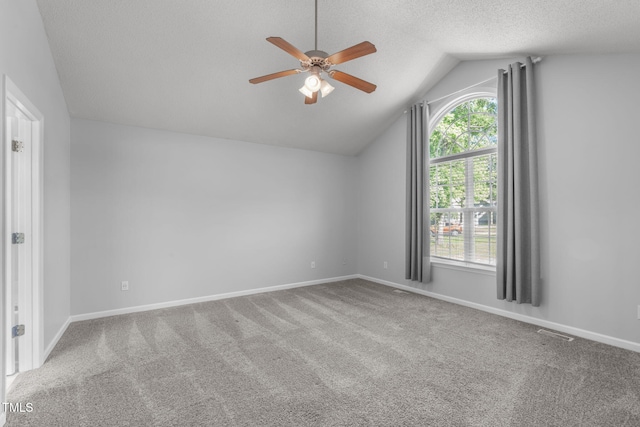 additional living space featuring a ceiling fan, lofted ceiling, carpet floors, a textured ceiling, and baseboards