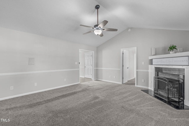 unfurnished living room featuring ceiling fan, a fireplace with raised hearth, vaulted ceiling, baseboards, and carpet flooring