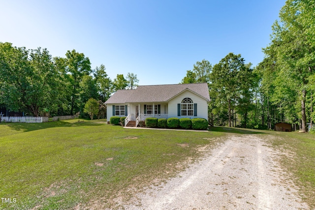 single story home featuring covered porch, dirt driveway, a storage shed, and an outdoor structure