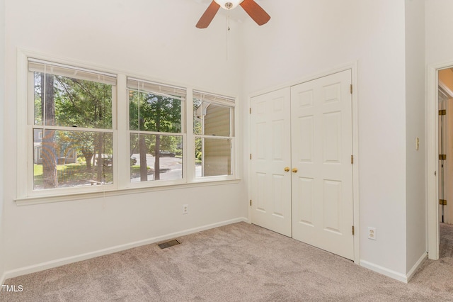 509 Darby Glen Ln, Durham, NC 27713 - unfurnished bedroom featuring light colored carpet, multiple windows, baseboards, and a high ceiling