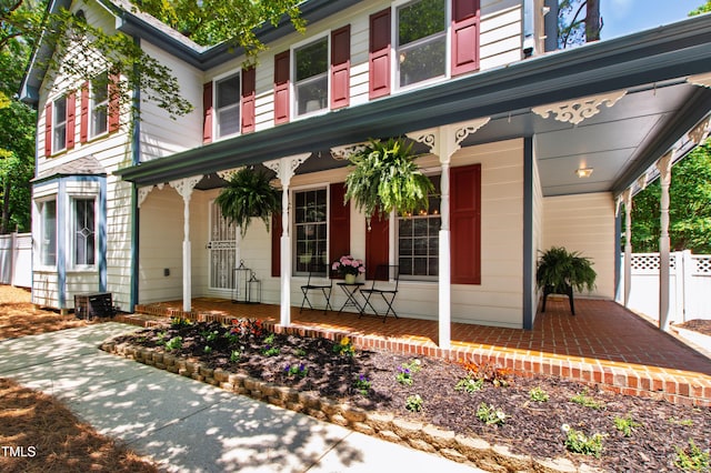 view of front of home featuring a porch and fence