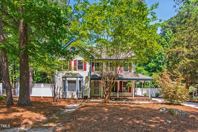 view of front of house featuring covered porch and fence