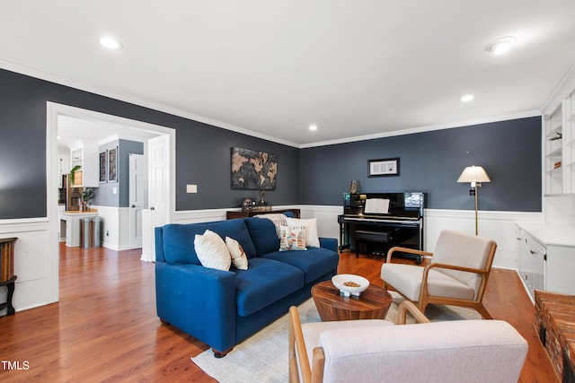 living room featuring wood finished floors, wainscoting, ornamental molding, and recessed lighting