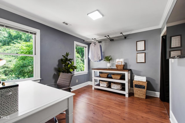 office space with ornamental molding, healthy amount of natural light, baseboards, and wood finished floors