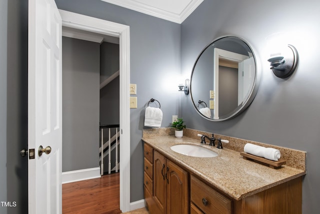 bathroom featuring ornamental molding, wood finished floors, and vanity