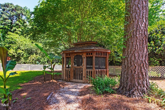 view of outdoor structure featuring fence and a gazebo