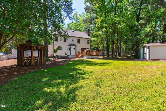 view of yard with a gazebo, a storage shed, an outbuilding, and a deck