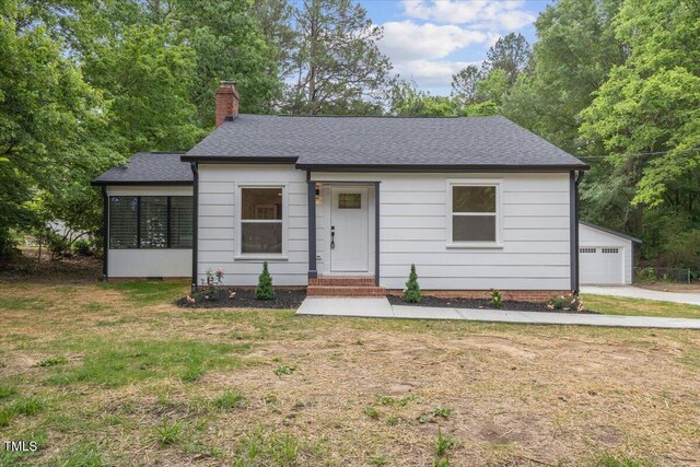 4713 Erwin Rd, Durham, NC 27705 - view of front facade with a chimney, roof with shingles, a front yard, and an outdoor structure
