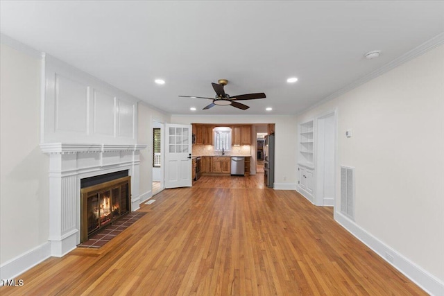4713 Erwin Rd, Durham, NC 27705 - unfurnished living room featuring ceiling fan, light wood-style floors, a tile fireplace, ornamental molding, and baseboards