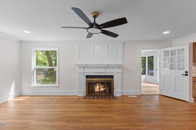 4713 Erwin Rd, Durham, NC 27705 - unfurnished living room with ornamental molding, plenty of natural light, light wood-style floors, a ceiling fan, and a fireplace with flush hearth
