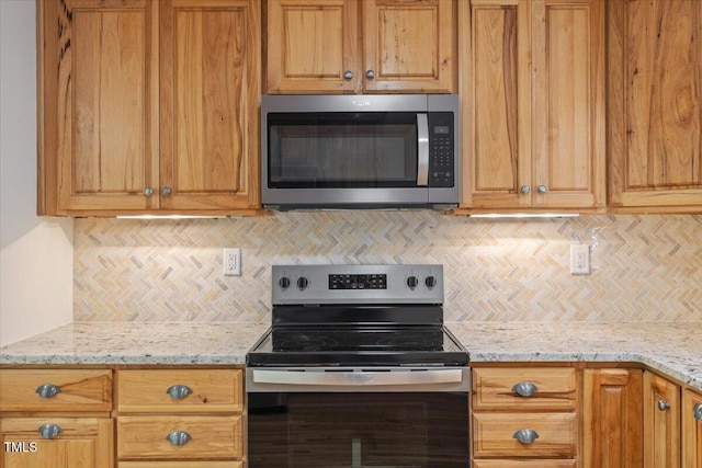 4713 Erwin Rd, Durham, NC 27705 - kitchen featuring appliances with stainless steel finishes, decorative backsplash, light stone countertops, and brown cabinetry
