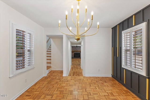 4713 Erwin Rd, Durham, NC 27705 - unfurnished dining area featuring a chandelier, stairs, baseboards, and a brick fireplace