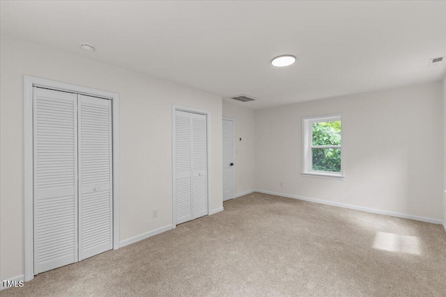 4713 Erwin Rd, Durham, NC 27705 - unfurnished bedroom with light carpet, multiple closets, and baseboards