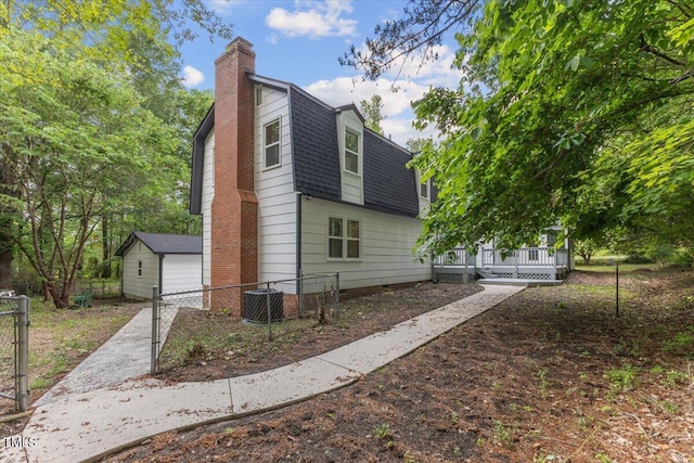 4713 Erwin Rd, Durham, NC 27705 - view of home's exterior with a chimney, a shingled roof, a gambrel roof, cooling unit, and a deck