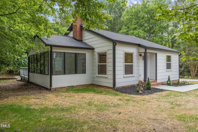4713 Erwin Rd, Durham, NC 27705 - view of front of home featuring a chimney, roof with shingles, a sunroom, and a front yard