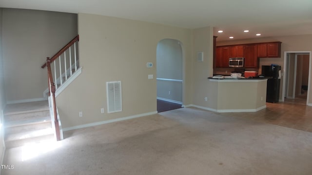 919 Middle Ground Ave, Rolesville, NC 27571 - unfurnished living room with recessed lighting, light colored carpet, arched walkways, baseboards, and stairway