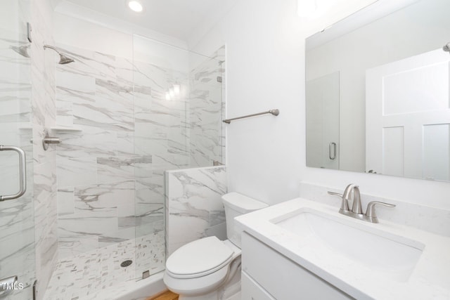 bathroom with a marble finish shower, vanity, and toilet