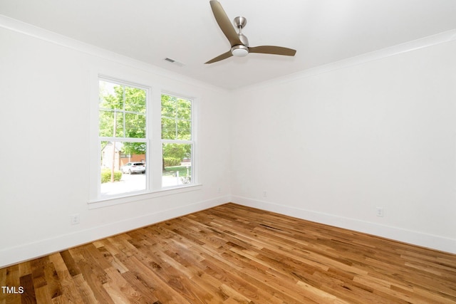 empty room featuring light wood-type flooring, baseboards, a ceiling fan, and ornamental molding