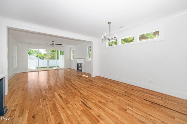 unfurnished living room featuring a glass covered fireplace, a chandelier, light wood finished floors, and baseboards